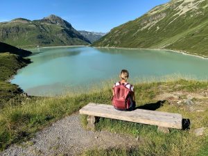 Mentale Klarheit für Frauen. Frau auf einer Bank am See in den Bergen.